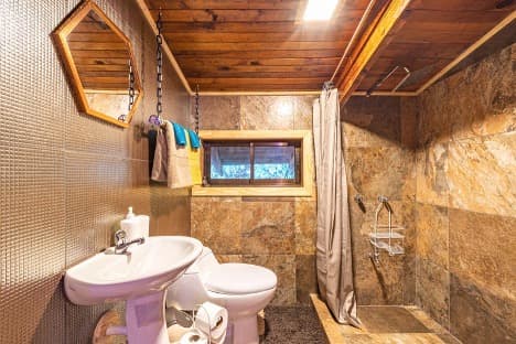 Natural stone bathroom with wood ceiling and soft ambient lighting