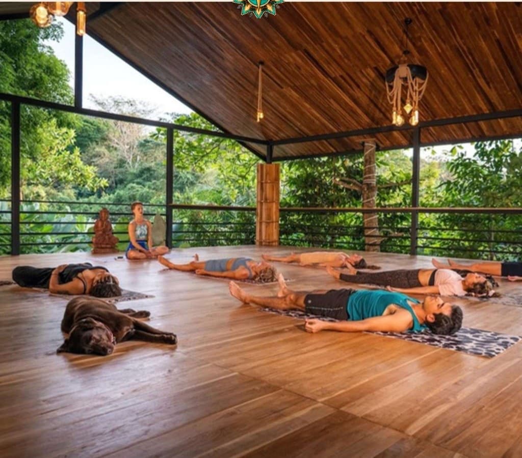 Guests resting in a guided breathwork session on the open-air wooden pavilion at Villa Wanderlust