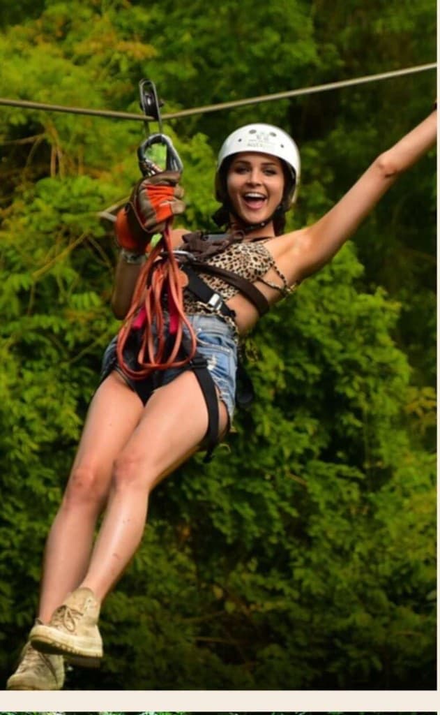 Guest smiling with joy while ziplining through the Costa Rican jungle canopy