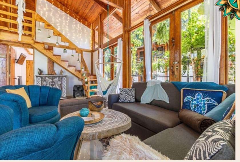 Bright open living room with vaulted wood ceilings and jungle views at Villa Wanderlust