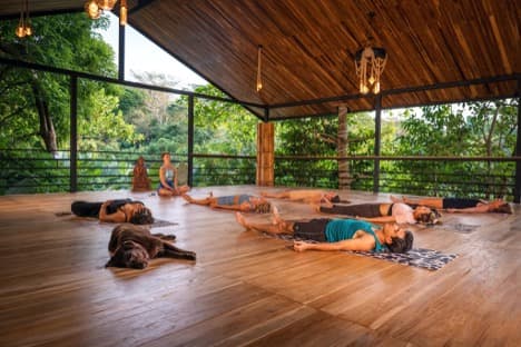 Guests resting in guided restoration on the open-air wooden pavilion at Villa Wanderlust